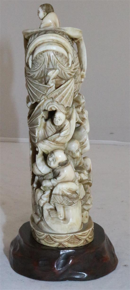 A Japanese walrus ivory okimono of men holding a giant carp, early 20th century, 15cm, wood stand